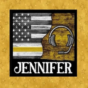 May include: A square image with a black border features a stylized American flag in black, white, and yellow, with a headset graphic. The name "JENNIFER" is displayed in bold white letters below the flag and headset design.