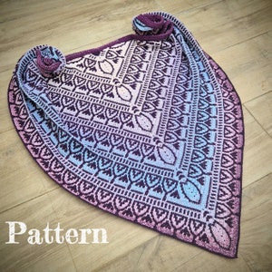 Könnte beinhalten: Ein gehäkeltes Tuch mit einem geometrischen Muster in Violett-, Blau- und Rosatönen. Das Tuch ist dreieckig und hat einen Fransenrand. Das Wort "Pattern" ist unten im Bild in weißer Schrift geschrieben.