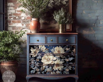 May include: A blue dresser with four drawers decorated with a floral print featuring white flowers and blue leaves. The dresser has gold knobs and sits on a patterned rug.