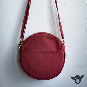 rote runde Umhängetasche aus festem Baumwollcanvas mit goldenem Reißverschluss, kleiner Eingrifftasche und verstellbarem Henkel für Frauen