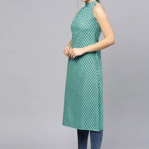 May include: A teal sleeveless dress with a high neck and a geometric pattern. The dress is knee-length and has a straight silhouette.