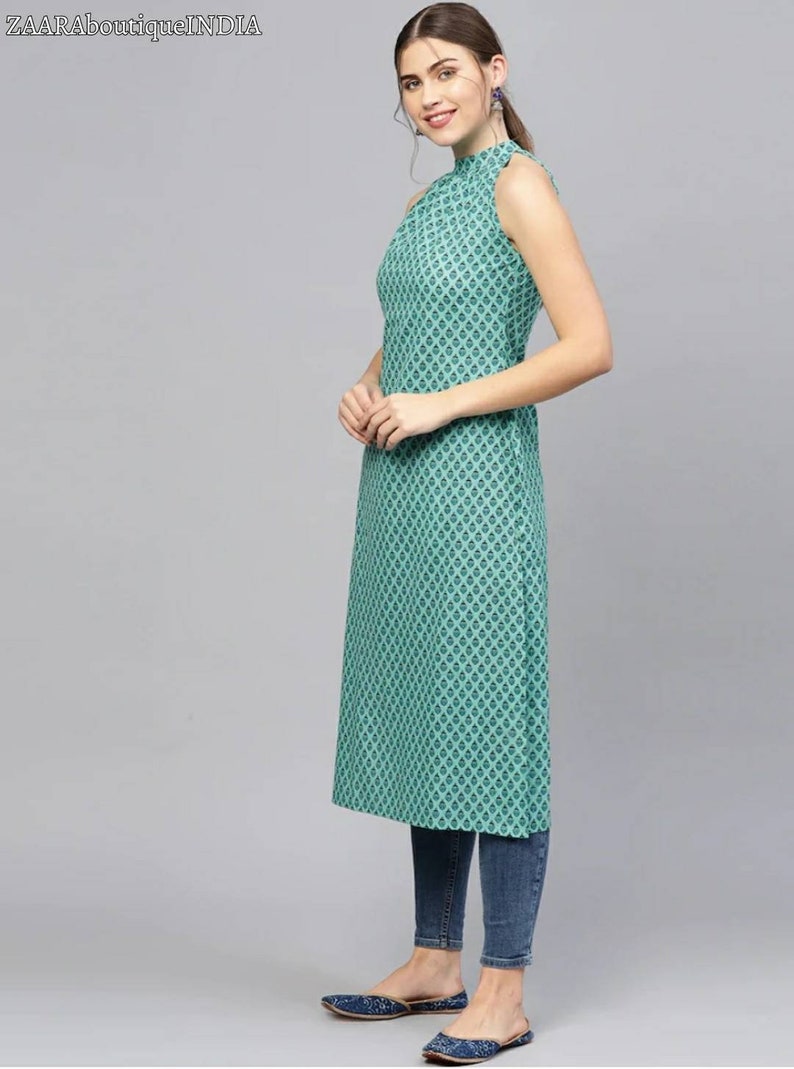 May include: A teal sleeveless dress with a high neck and a geometric pattern. The dress is knee-length and has a straight silhouette.