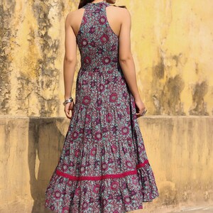 May include: A blue and pink floral print maxi dress with a halter neckline and tiered skirt. The dress has a fitted bodice and a flowy skirt.