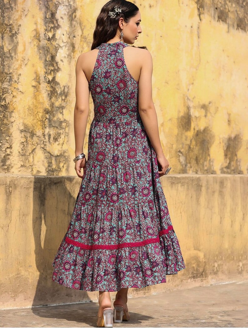 May include: A blue and pink floral print maxi dress with a halter neckline and tiered skirt. The dress has a fitted bodice and a flowy skirt.
