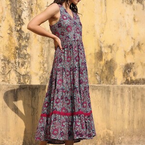 May include: A sleeveless maxi dress with a floral print in shades of blue, pink, and purple. The dress has a tiered skirt and a lace trim at the hem.