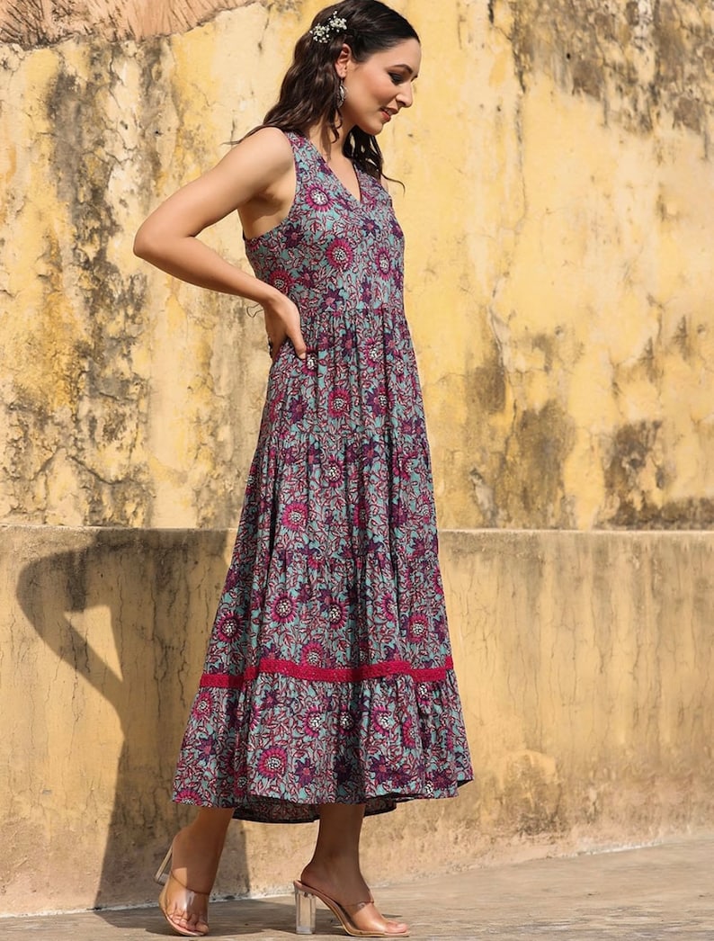 May include: A sleeveless maxi dress with a floral print in shades of blue, pink, and purple. The dress has a tiered skirt and a lace trim at the hem.