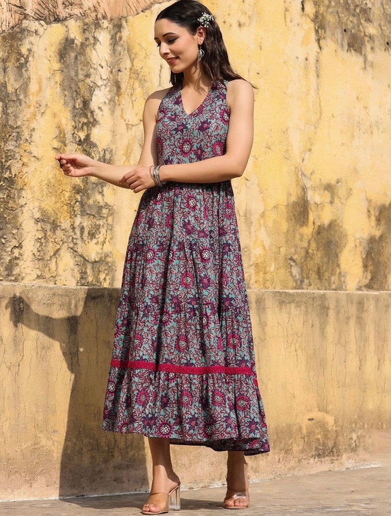 May include: A blue and pink floral print maxi dress with a halter neckline and a tiered skirt. The dress has a red trim at the hem.