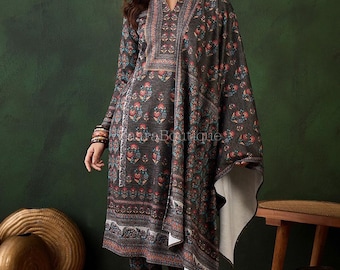May include: A dark grey floral print outfit comprising a long-sleeved tunic, trousers, and a shawl. The ensemble features a V-neck and is decorated with red, blue, and white floral patterns. The model is wearing earrings and bracelets.