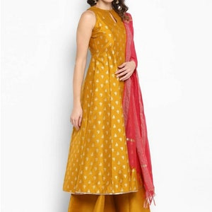 May include: A mustard yellow sleeveless kurta with a gold floral print and a matching palazzo pant. The kurta has a keyhole neckline and a pink dupatta with a gold border.