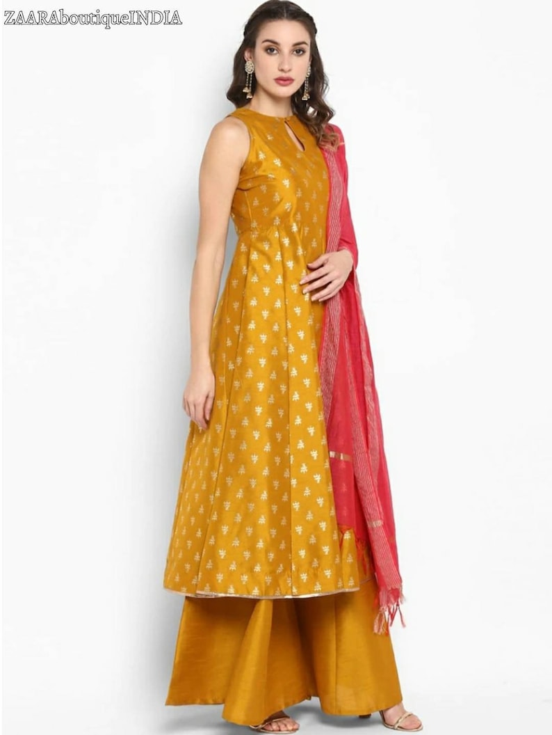 May include: A mustard yellow sleeveless kurta with a gold floral print and a matching palazzo pant. The kurta has a keyhole neckline and a pink dupatta with a gold border.