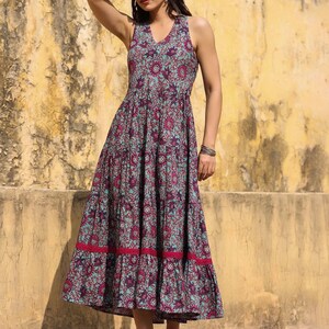 May include: A sleeveless maxi dress with a floral print in shades of blue, pink, and purple. The dress has a tiered skirt and a ruffled hem.