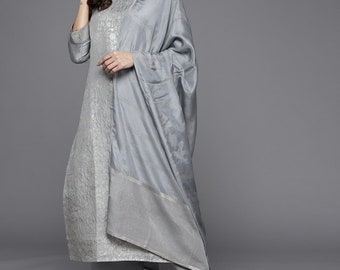 May include: A grey kurta set with silver embroidery. The kurta has three-quarter sleeves and a round neckline. The set includes matching trousers and a dupatta.