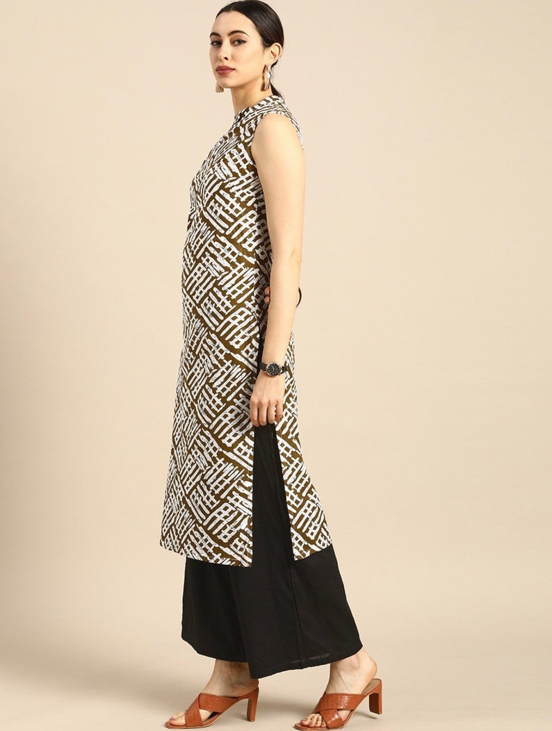 May include: A sleeveless white and brown patterned kurta with a mandarin collar and a side slit. The kurta is paired with black palazzo pants.