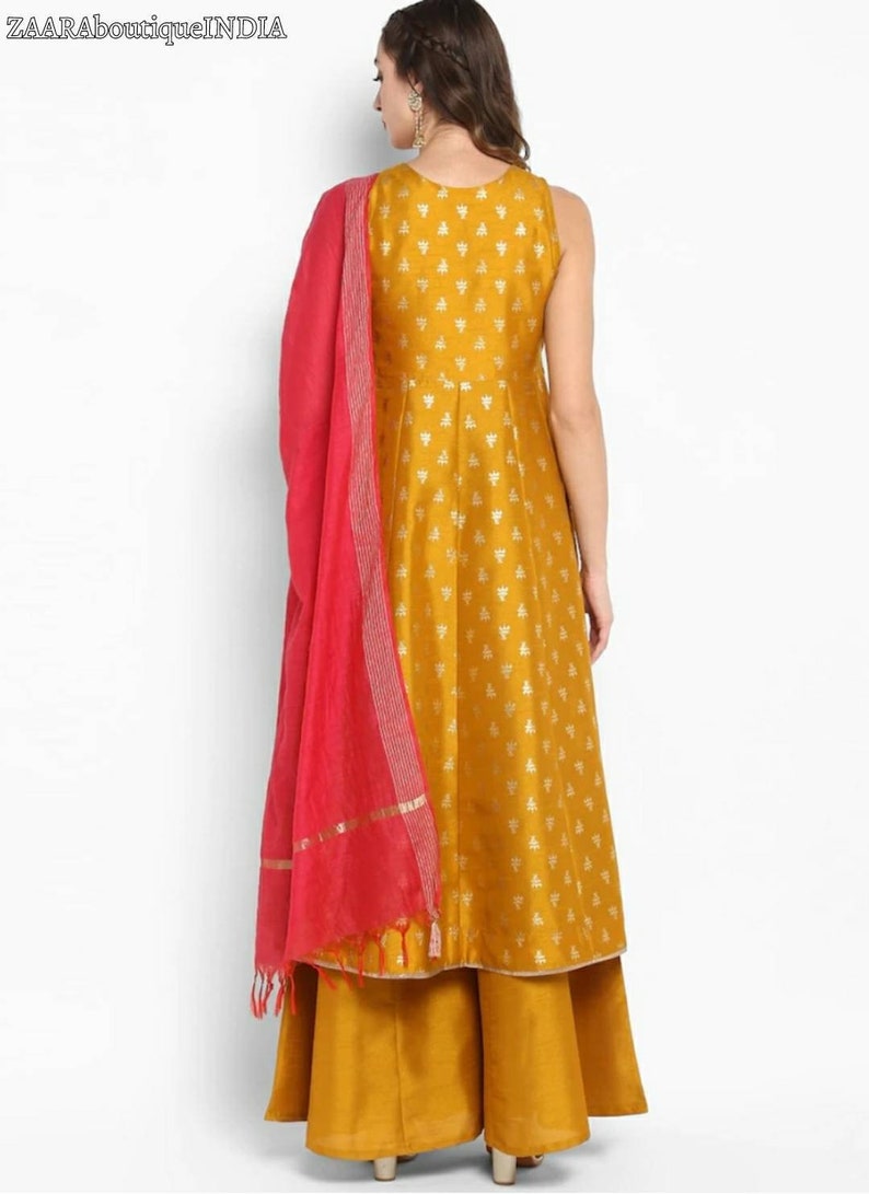 May include: A mustard yellow sleeveless kurta with a gold print and a matching palazzo pant. The kurta has a round neckline and a pink dupatta with gold trim.