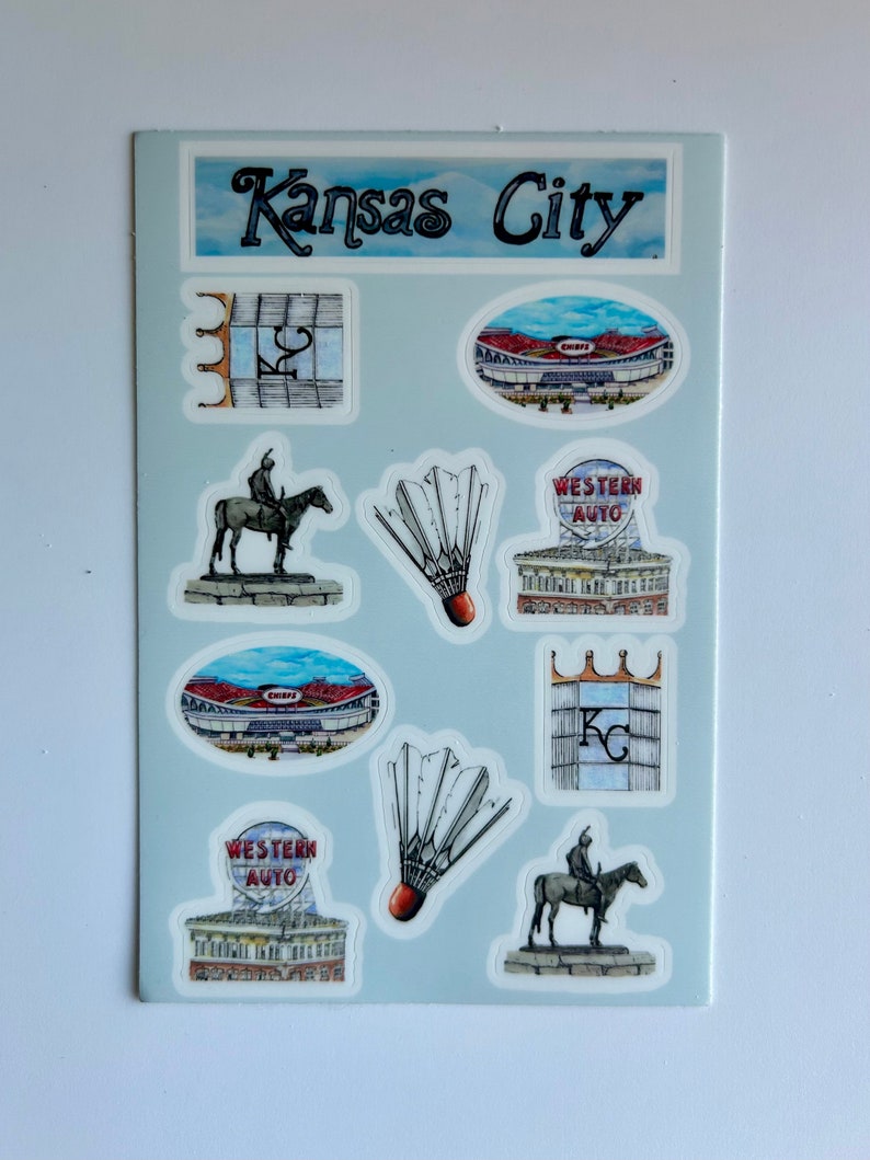 Pode incluir: Uma folha de adesivos com v&aacute;rios marcos e s&iacute;mbolos de Kansas City, incluindo o horizonte da cidade, uma est&aacute;tua de um cavaleiro a cavalo, um est&aacute;dio e um volante de badminton. A folha tamb&eacute;m inclui o texto "Kansas City" e "Western Auto".