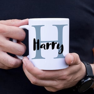 Può includere: Tazza in ceramica bianca con una lettera H grigia e il nome Harry stampato in nero.