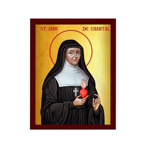 Puede incluir: Un icono religioso que representa a Santa Juana de Chantal, una santa francesa, vestida con un hábito negro y sosteniendo un corazón rojo con una llama en la parte superior. El icono tiene un fondo dorado y un marco de madera con el texto "ST. JANE DE CHANTAL" en la parte superior.