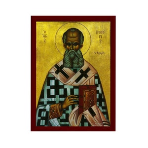 Op de afbeelding: Een religieus icoon dat een man met een baard voorstelt in een groen-wit geruite gewaad, die een boek vasthoudt. Het icoon heeft een gouden achtergrond en een rood frame. De tekst "ΓΡΗΓΟΡΙΟ" is in het Grieks geschreven aan de rechterkant van het icoon.