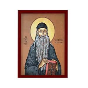 Może przedstawiać: Ikona Serafina z Platyny, rosyjskiego świętego prawosławnego. Ikona przedstawia Serafina w czarnej szacie z długą białą brodą, trzymającego książkę. Ikona jest oprawiona w ciemnoczerwoną ramę.