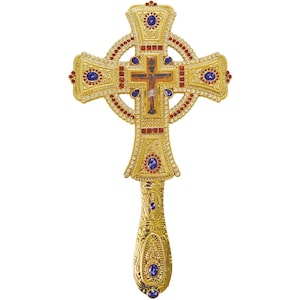 May include: A gold-toned metal processional cross featuring a central crucifix icon, surrounded by a circular halo frame. The cross is embellished with numerous clear rhinestones, red square stones, and oval blue cabochons, with an ornate handle.