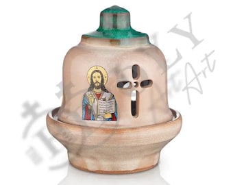 May include: A ceramic incense burner with a green top and a white base. The burner features a depiction of Jesus holding a book and a cross cutout.