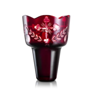 Può includere: Un portacandele votivo in vetro rosso rubino con bordo smerlato. Il portacandele presenta disegni floreali e a croce incisi. La base ha una forma cilindrica solida. Il vetro ha una finitura lucida.