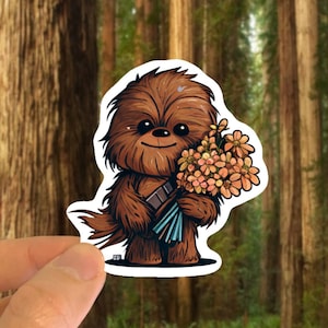 May include: A cartoon illustration of Chewbacca holding a bouquet of orange flowers. The illustration is in a sticker format with a white border.