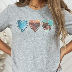 Ocean shirt that has 3 hearts filled with different ocean photos.