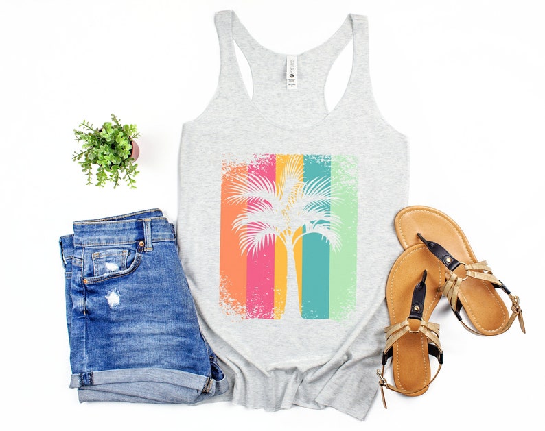 A white heathered tank top with a distressed, retro-style palm tree graphic on stripes of shades of pink, orange, yellow, green, and blue.