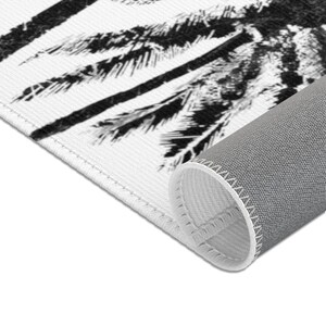 Peut inclure: Tapis de sol &agrave; motif de palmiers noir et blanc avec un dos gris et des coutures blanches autour des bords.