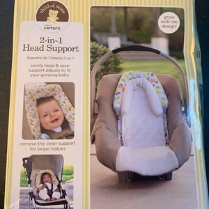 May include: A product packaging box for a 2-in-1 head support for babies. The box is yellow with green stripes and features a photo of the head support in use in a car seat and a stroller. The text on the box reads 'child of mine', 'carter's', '2-in-1 Head Support', 'Soporte de Cabeza 2 en 1', 'comfy head & neck support adjusts to fit your growing baby', 'remove the inner support for larger babies', 'perfect for car seats, strollers, bouncers & joggers', 'surround your little one in comfort', and 'grow with me design!'.