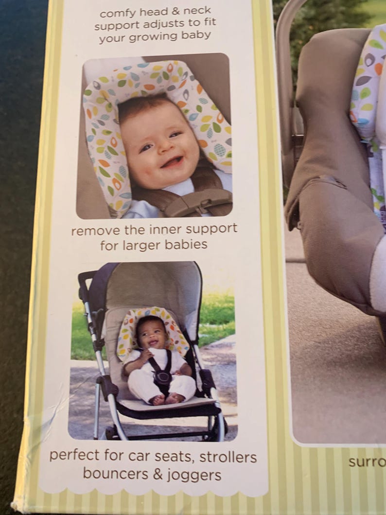 May include: A baby head support for car seats, strollers, bouncers, and joggers. The support is made of soft fabric with a green and white leaf pattern. The support is adjustable to fit a growing baby. The text on the package reads 'comfy head & neck support adjusts to fit your growing baby', 'remove the inner support for larger babies', and 'perfect for car seats, strollers bouncers & joggers'.