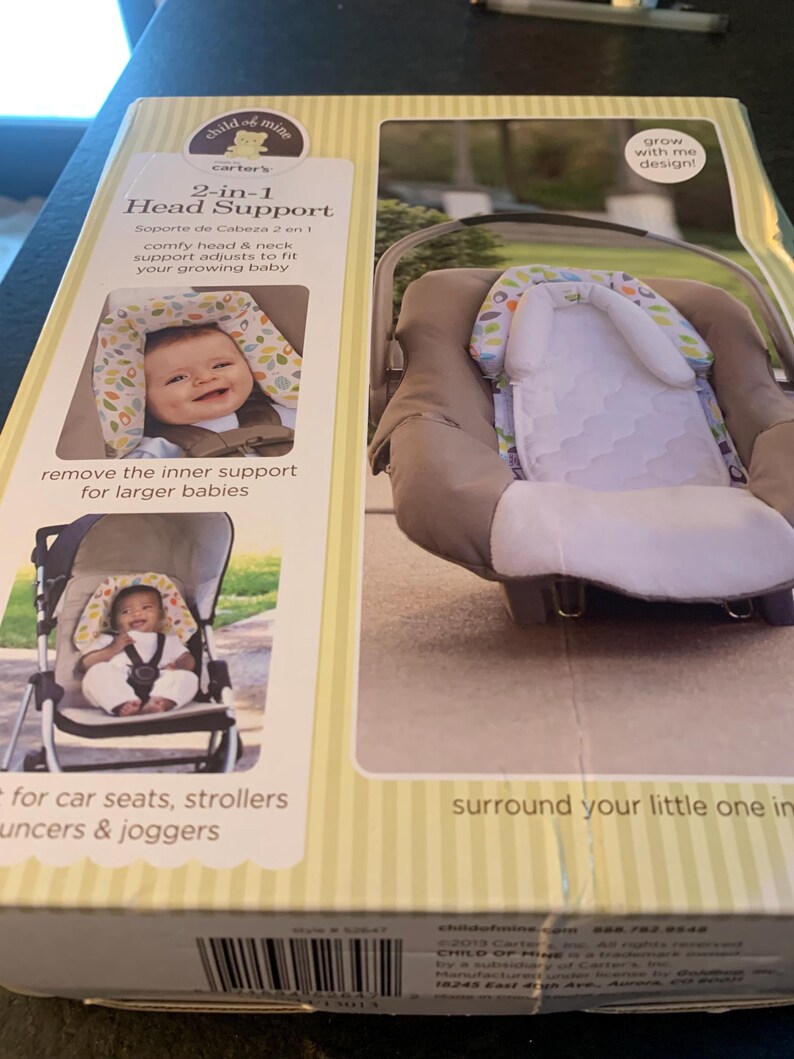 May include: A box for a Carter's Child of Mine 2-in-1 Head Support. The box is yellow and white with a picture of a baby in a car seat and a stroller. The text on the box reads '2-in-1 Head Support', 'comfy head & neck support adjusts to fit your growing baby', 'remove the inner support for larger babies', 'for car seats, strollers, bouncers & joggers', 'surround your little one in comfort', 'grow with me design!'.