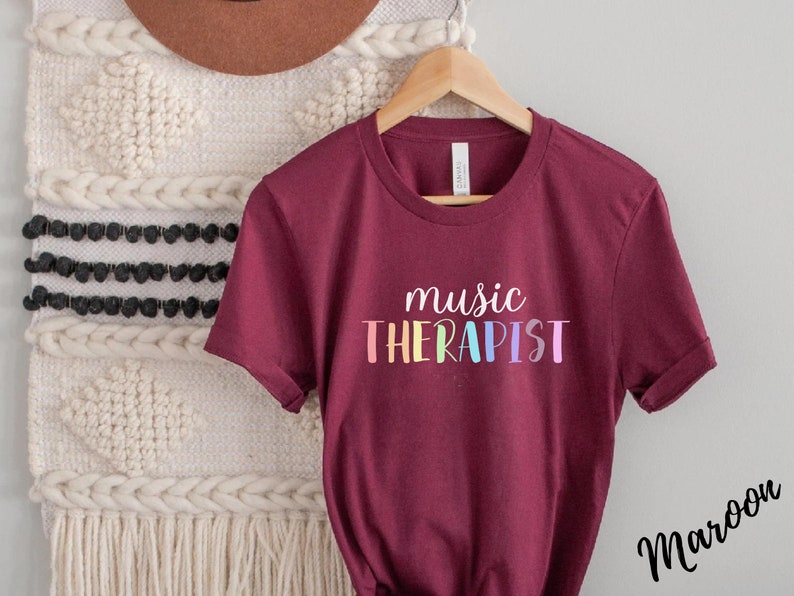 May include: Maroon t-shirt with the text "music THERAPIST" in rainbow colors.