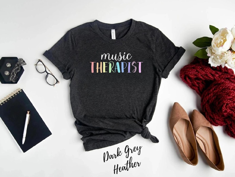 May include: Dark heather grey t-shirt with the text "music therapist" in rainbow colors.