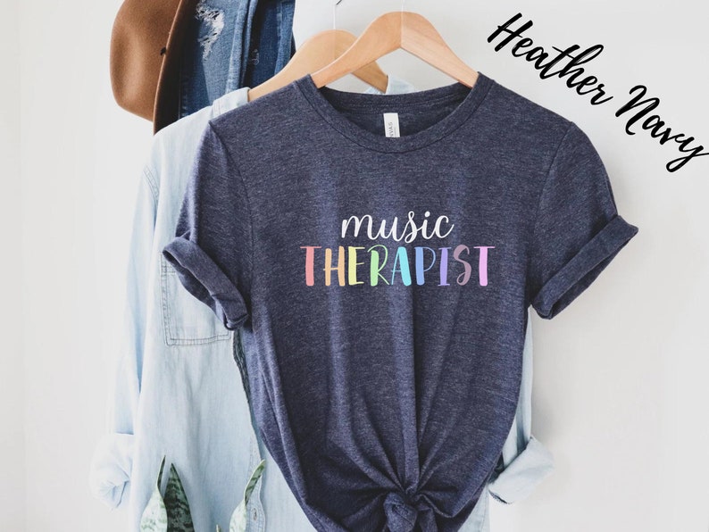 May include: A heather navy blue t-shirt with the text "music therapist" in rainbow colors.