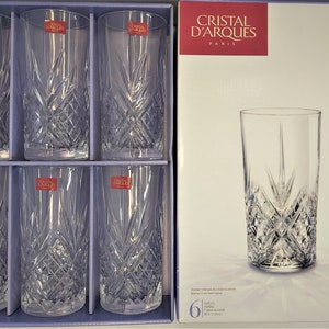 May include: Set of six clear glass highball glasses with a cut crystal design. The glasses are packaged in a box with the brand name "Cristal d'Arques" and the product name "Masquerade" printed on it.