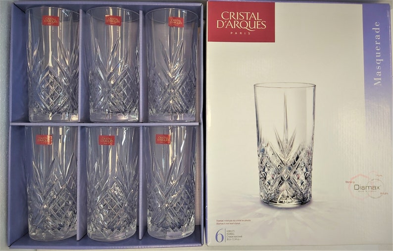 May include: Set of six clear glass highball glasses with a cut crystal design. The glasses are packaged in a box with the brand name "Cristal d'Arques" and the product name "Masquerade" printed on it.