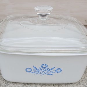 Puede incluir: Plato para hornear cuadrado blanco con tapa de vidrio y diseño floral azul. El plato tiene un diseño simple y clásico.