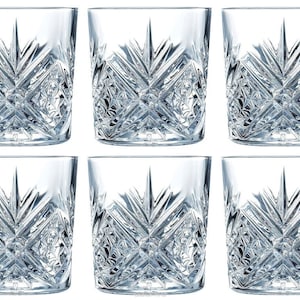 Puede incluir: Juego de seis vasos de cristal transparente con diseño de cristal tallado. Los vasos tienen forma cuadrada y una base ancha.