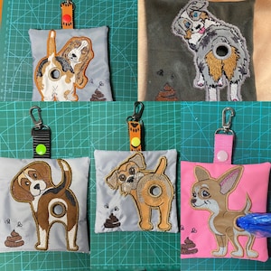 Könnte beinhalten: Fünf verschiedene Hundekotbeutelhalter mit gestickten Hundemotiven. Die Halter sind aus Stoff und haben einen Kordelverschluss. Die Designs umfassen einen Basset Hound, einen Beagle, einen Chihuahua, einen Australian Shepherd und einen Terrier.