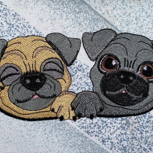 May include: Two embroidered pug dogs, one with brown fur and closed eyes, the other with gray fur and open eyes, both with pink noses and black eyes.