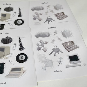 Puede incluir: Un conjunto de pegatinas con varias ilustraciones en blanco y negro, que incluyen una computadora, una nube, un animal de globo, una silla, una vela, una llave, una caja de huevos y una bola negra de 8. Las pegatinas est&aacute;n en hojas de papel blancas con el texto "uriuo." y "white." impreso en ellas.
