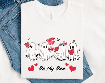 May include: White t-shirt with a graphic of four ghosts holding red hearts and balloons. The text "Be My Boo" is printed below the ghosts.