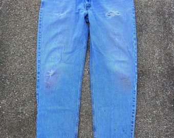 Vintage 1990s 550 relaxed 37x33 100% cotton denim jeans. Red tab. Distressed and some stains. Tear/hole on left hip below pocket.