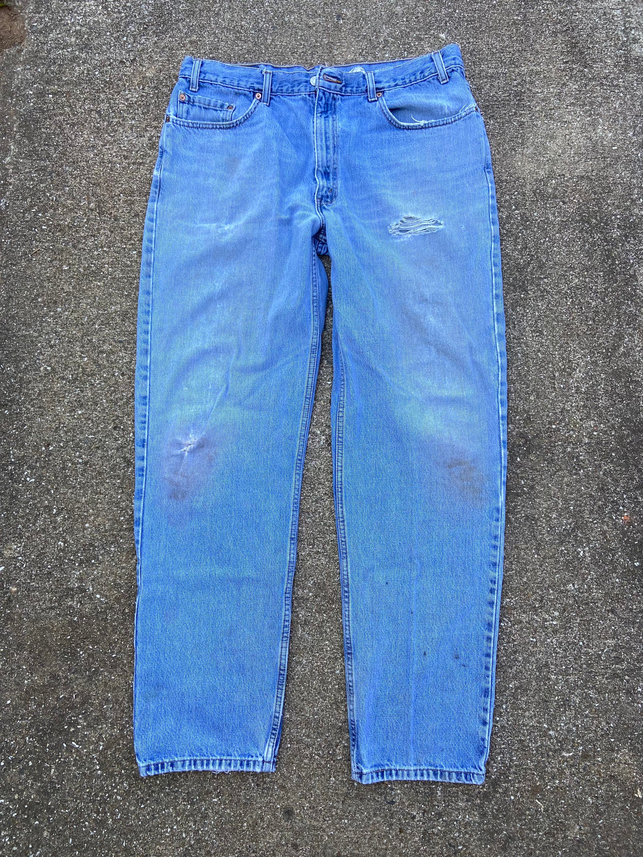 Vintage 1990s 550 relaxed 37x33 100% cotton denim jeans. Red tab. Distressed and some stains. Tear/hole on left hip below pocket.