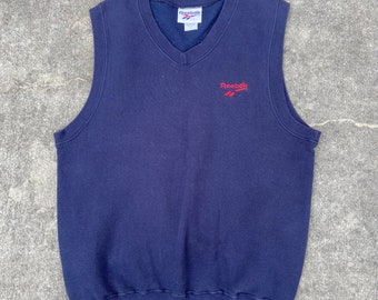 Vintage Reebok small/medium sweatshirt vest. Navy blue with red Reebok logo on front left chest. 80/20 cotton/fortel. Made in the USA.
