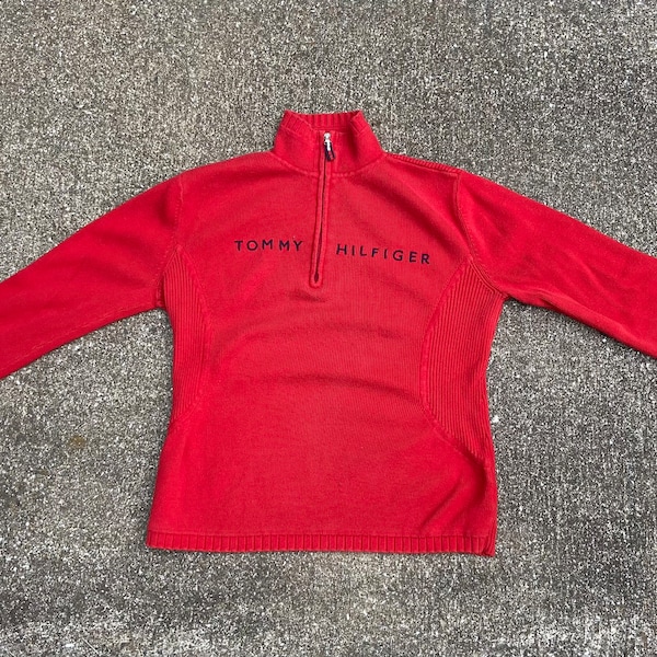 Vintage kleine rode Tommy Hilfiger pullover met 1/3 ritssluiting. Gemaakt in Hongkong. Goede conditie. Vertoont wel gebruikssporen en wat vervaagd.