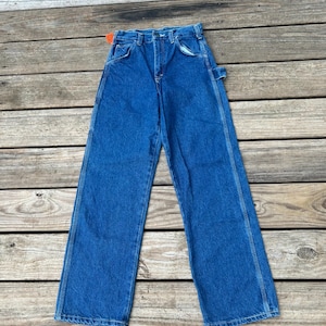 May include: A pair of blue denim carpenter jeans with a hammer loop on the right side.