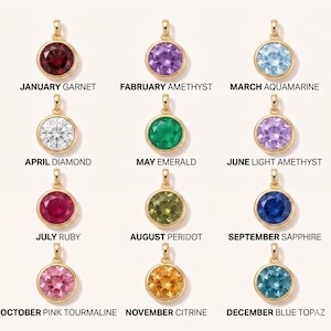 May include: A collection of twelve gold-colored pendants, each featuring a different gemstone. The gemstones are round and set in a gold bezel. Each pendant is labeled with a month and gemstone name, including Garnet, Amethyst, Aquamarine, Diamond, Emerald, and Ruby.